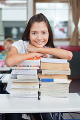 Image showing Schoolgirl Leaning On Stacked Books At Desk