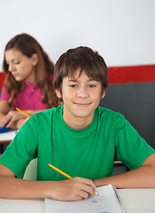 Image showing Portrait Of Teenage Male Student Sitting At Desk