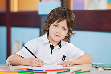 Image showing Boy With Sketch Pen And Paper At Desk