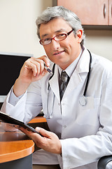 Image showing Doctor Sitting At Desk In Clinic