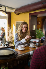 Image showing Woman Making Payment Through Mobilephone At Counter