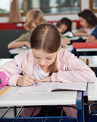 Image showing Schoolgirl Writing At Desk