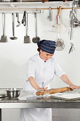 Image showing Happy Female Chef Rolling Dough