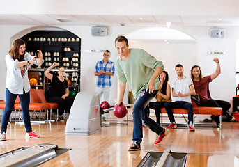 Image showing Man Bowling With Friends Cheering in Club