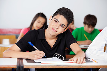 Image showing Teenage Boy Writing At In Classroom