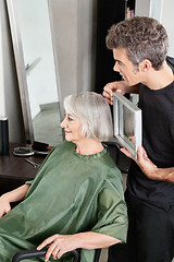 Image showing Hairdresser Holding Mirror Behind Senior Woman