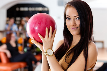 Image showing Young Woman Holding Pink Ball in Bowling Club