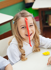 Image showing Happy Little Girl With Clay Stuck On Forehead