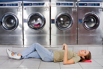 Image showing Woman Listening To Music While Lying At Laundry