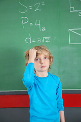 Image showing Sad Schoolboy Standing Against Board In Classroom