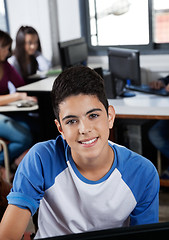 Image showing Happy Teenage Schoolgirl Sitting In Computer Lab