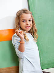 Image showing Girl With Chalk Standing By Chalkboard In Class