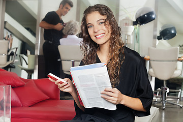 Image showing Woman With Mobile Phone And Magazine At Hair Salon