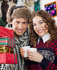 Image showing Couple With Presents And Coffee At Christmas Store