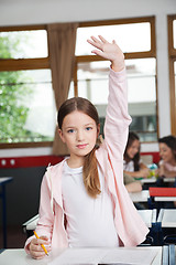 Image showing Schoolgirl Raising Hand While Standing In Classroom