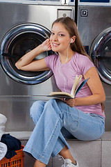 Image showing Woman With Book Listening To Music In Laundry