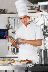 Image showing Chef Holding Tablet With Pasta Dishes At Counter