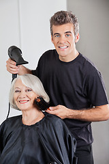 Image showing Hairstylist With Dryer Setting Up Woman's Hair