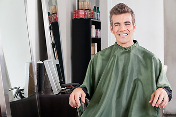 Image showing Male Customer In Apron Sitting At Hair Salon