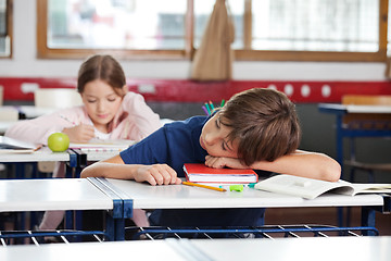 Image showing Boy Sleeping On Desk In Classroom