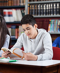 Image showing Teenage Schoolboy Reading Book In Library