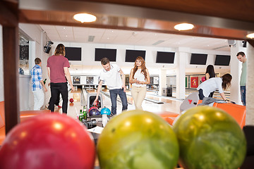 Image showing People Bowling With Balls in Foreground