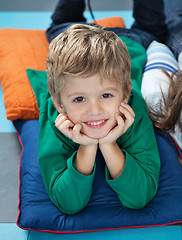 Image showing Boy With Head In Hands Lying On Cushions In Kindergarten