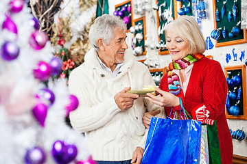 Image showing Couple Holding Present At Christmas Store