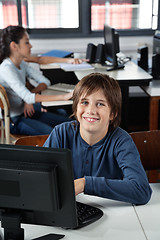 Image showing Happy Schoolboy Sitting With Computer At Desk