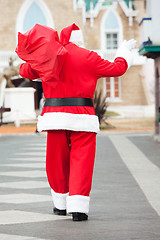 Image showing Santa Claus With Bag Waving While Walking In Courtyard