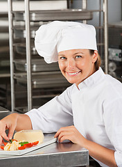 Image showing Happy Female Chef Garnishing Dish
