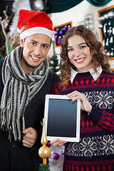 Image showing Happy Couple Showing Digital Tablet At Christmas Store