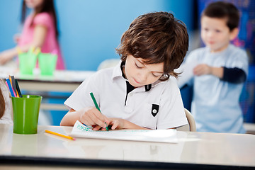 Image showing Boy Drawing With Sketch Pen At Desk In Kindergarten