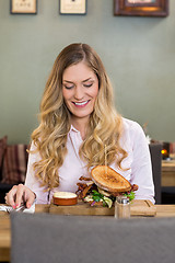 Image showing Young Woman Looking At Burger