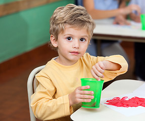 Image showing Little Boy Washing Paintbrush In Glass