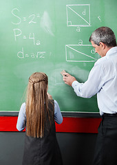 Image showing Girl Standing With Teacher Wiping Board