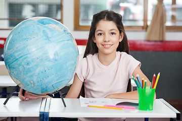 Image showing Schoolgirl Smiling With Globe