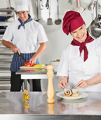 Image showing Female Chef Garnishing Dish In Kitchen