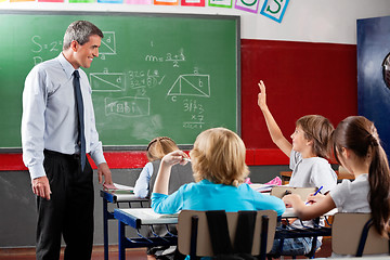 Image showing Professor Looking At Schoolboy Raising Hand