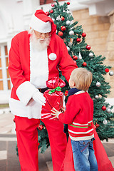 Image showing Santa Claus Giving Gift To Boy