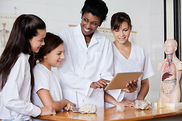 Image showing Teacher Looking At Schoolgirls While Using Tablet In Biology Cla