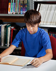 Image showing Teenage Schoolboy Reading Book In Library