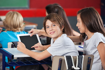 Image showing Boy With Girl Using Digital Tablet At Desk