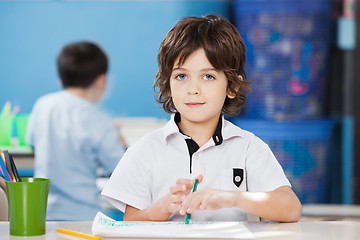 Image showing Cute Boy With Paper And Sketch Pen At Desk