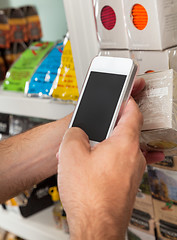 Image showing Man's Hand With Smart Phone Scanning Product