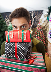 Image showing Man Looking Over Stacked Christmas Gifts In Store