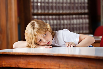 Image showing Thoughtful Schoolboy Leaning On Table In Library