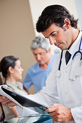 Image showing Doctor Reading Document At Reception