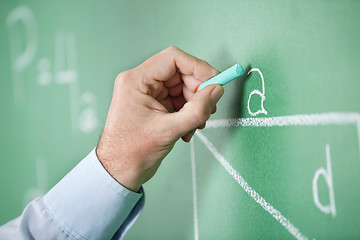 Image showing Mature Teacher'S Hand Writing Alphabet On Greenboard