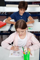 Image showing Schoolgirl Drawing At Desk In Classroom